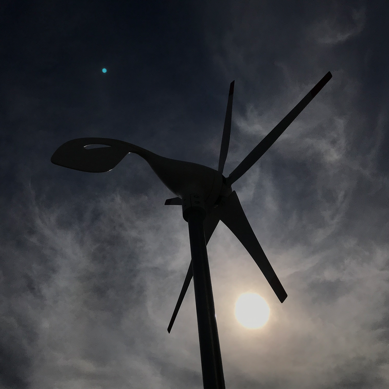 Nature's Generator 150W Wind Turbine - Scene - Silhouette of a wind turbine against a dark sky with clouds and moon. 8