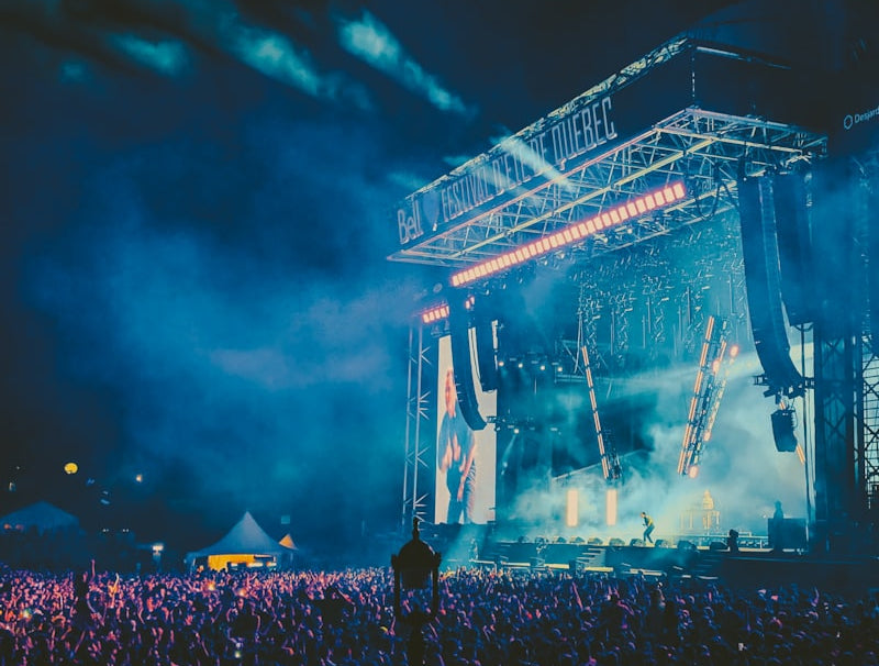 Concert scene with a large crowd and stage lights at night